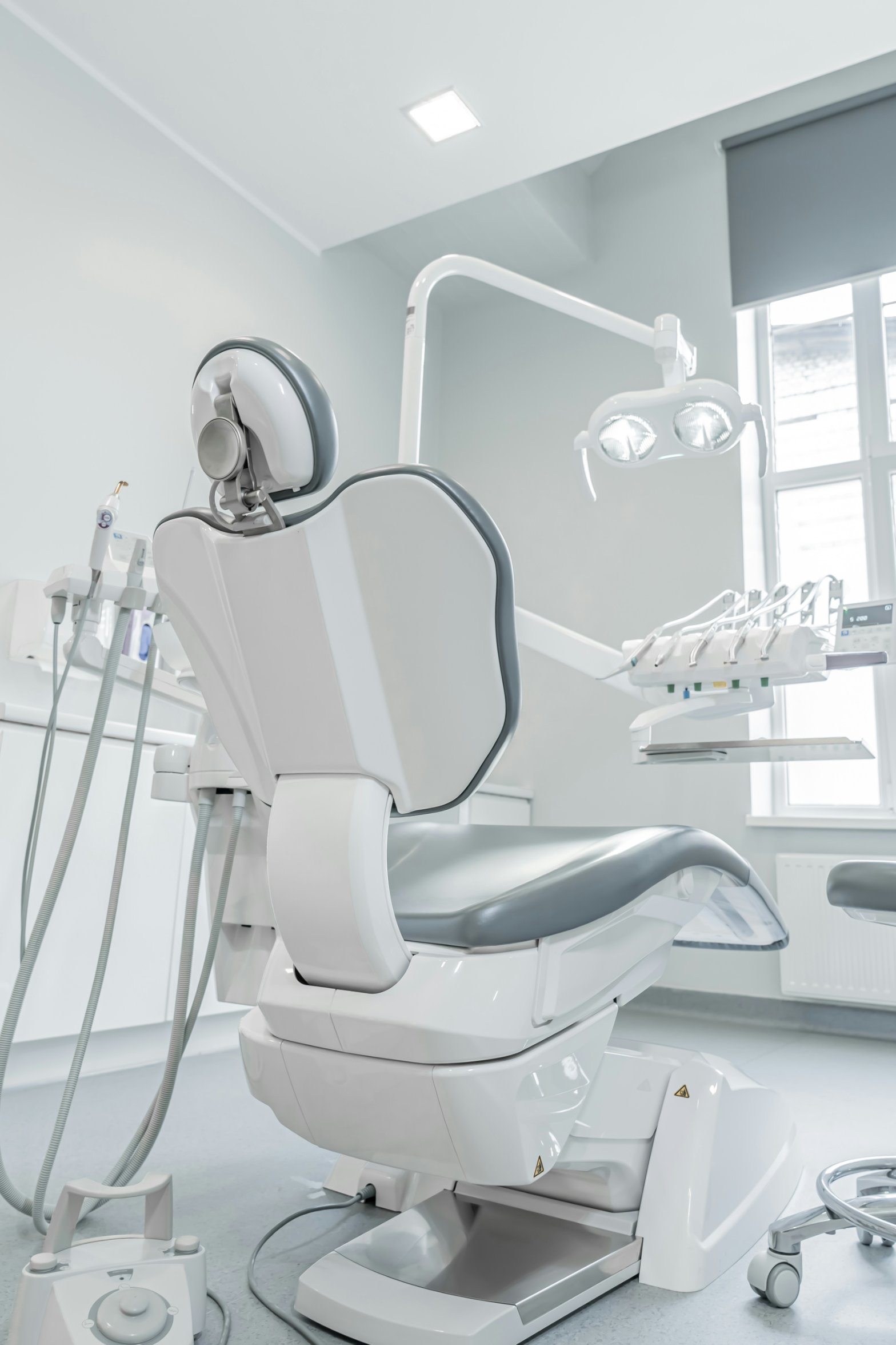 A white dental chair in a bright, modern operatory